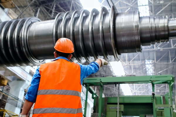 Consultant spécialisé en maintenance industrielle inspectant un système mécanique